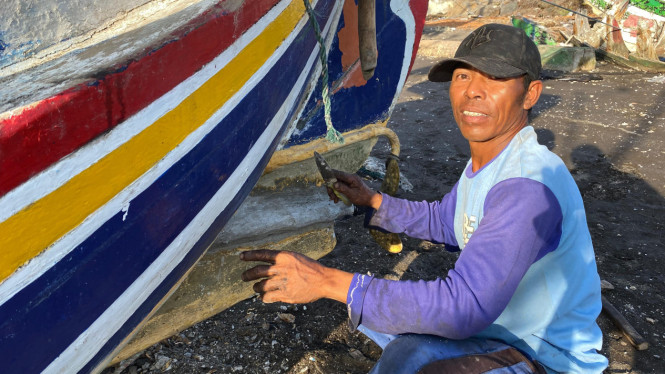 Sosok Tutus, nelayan asal Kalbut saat membersihkan perahu miliknya