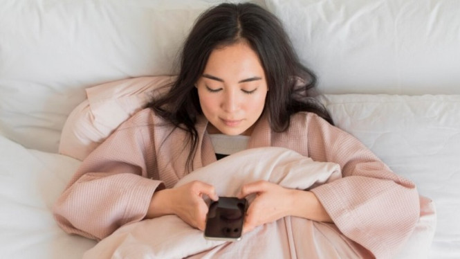 Ilustrasi seseorang yang selalu scroll hp saat bangun tidur