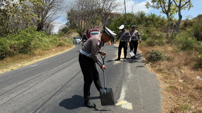 Petugas menaburkan pasir pada tumpahan solar