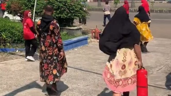 Petugas Damkar yang Sedang Mengenakan Daster Berlari