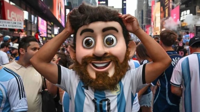 Pendukung Tim Nasional Argentina mengenakan topeng pesepak
