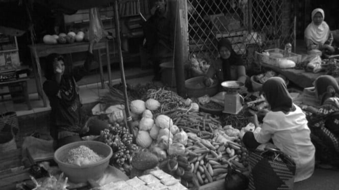 Warga melakukan transaksi kebutuhan pokok di pasar