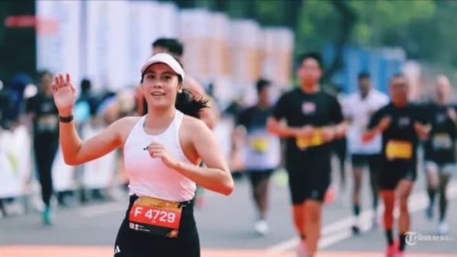 Potret pelari wanita yang sedang mengikut event lari marathon
