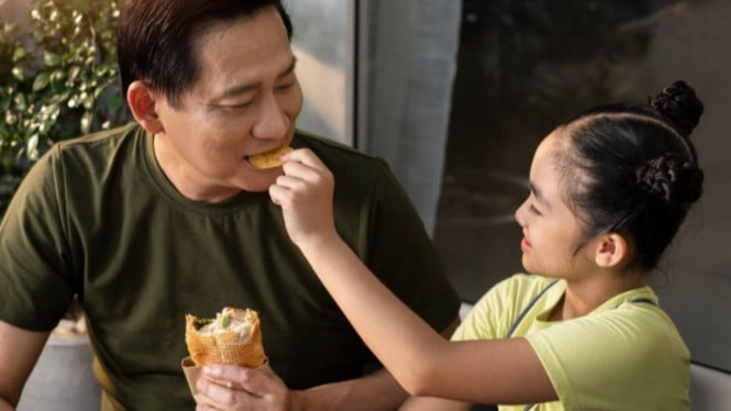 Orangtua dan anak makan snack (camilan) bersama