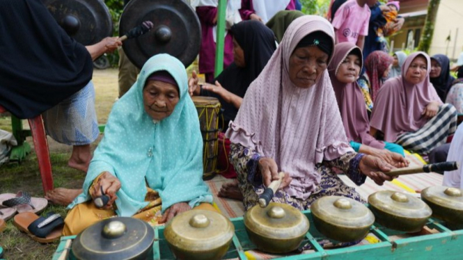 Ibu-ibu Kampung Tanjung memainkan gondang oguang