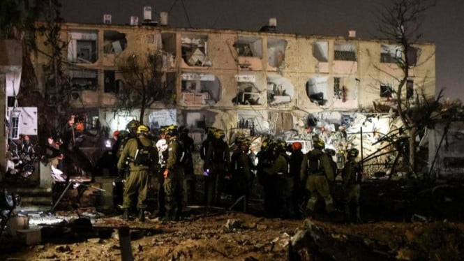 Tentara Israel bekerja di lokasi kerusakan akibat rudal Iran