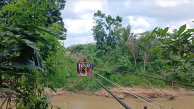Anak-anak di Kutai Kartanegara pulang sekolah menggunakan kereta gantung melintasi sungai