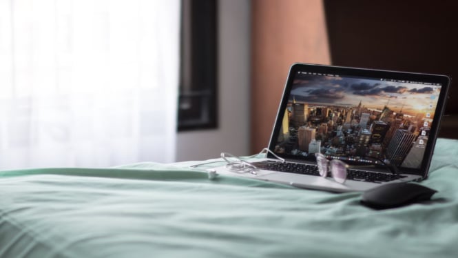 Ilustrasi Laptop di Atas Kasur