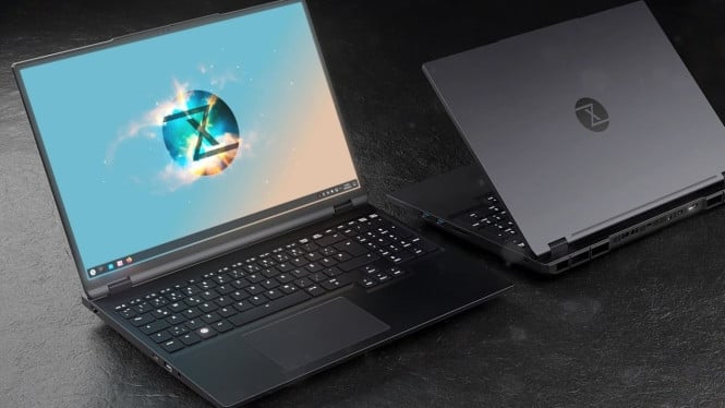 Tuxedo Stellaris 16 Gen 8 laptop gaming dengan desain aluminium berwarna gelap terbuka di atas meja, menunjukkan keyboard backlit.