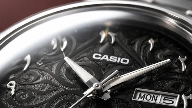 Detail dial hitam Casio MTP-E735AR yang dihiasi ukiran arabesque serta indikator hari dan tanggal.
