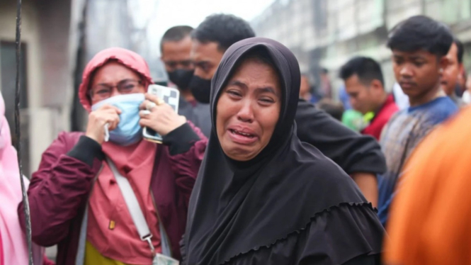 Warga menangis di tengah puing-puing akibat kebakaran depo Plumpang