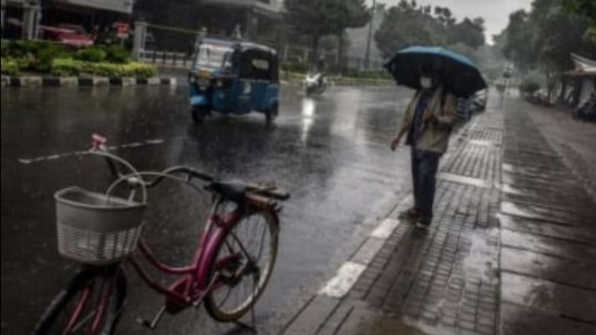 Ilustrasi Warga Menganakan Payung Saat Hujan di Jakarta