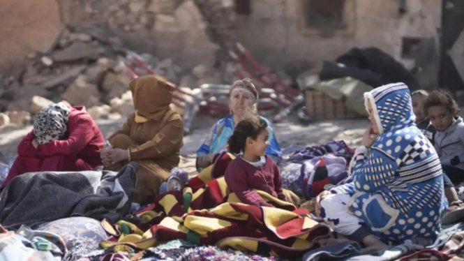 Keluarga korban gempa Maroko tidur di luar rumahnya yang runtuh.