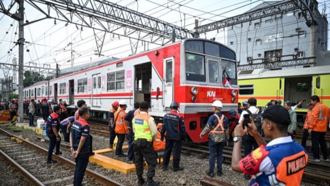 Petugas mengevakuasi rangkaian KRL Bogor-Jakarta Kota yang anjlok.