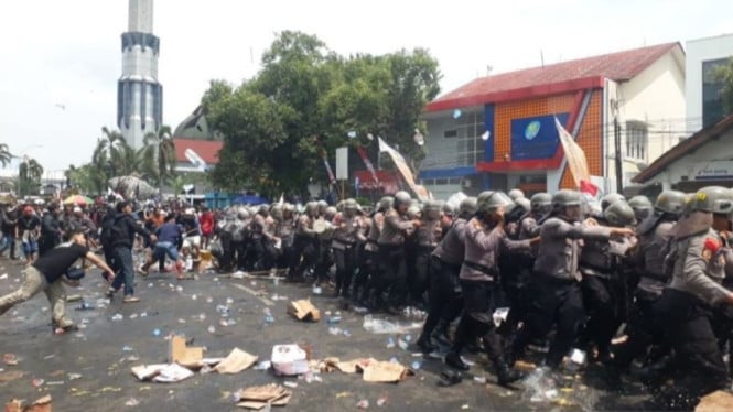 Polisi menyelamatkan diri dari amukan massa saat demo di Pati.