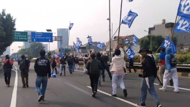 Massa aksi demo di DPR saat masuk jalan tol di Jakarta