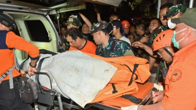 Petugas memindahkan kantong jenazah korban banjir di Bali.