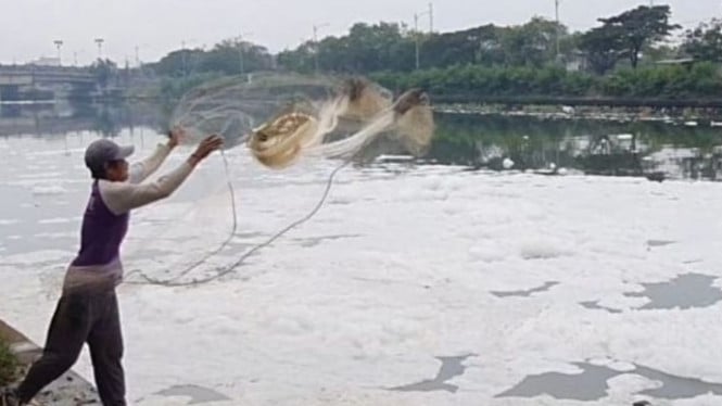 Aktivitas warga di Marunda dalam kondisi air berbusa.