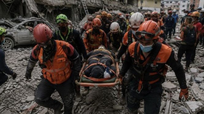 Ilustrasi tim evakuasi gotong korban gempa Venezuela.