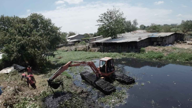 Pembersihkan sampah dan eceng gondok di sungai