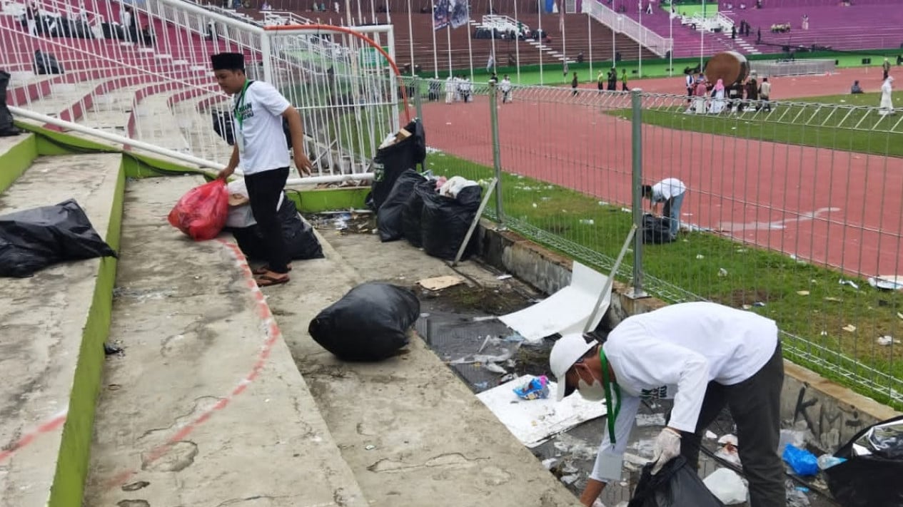 Nampak relawan membersihkan sampah di lokasi resepsi 1 Abad NU