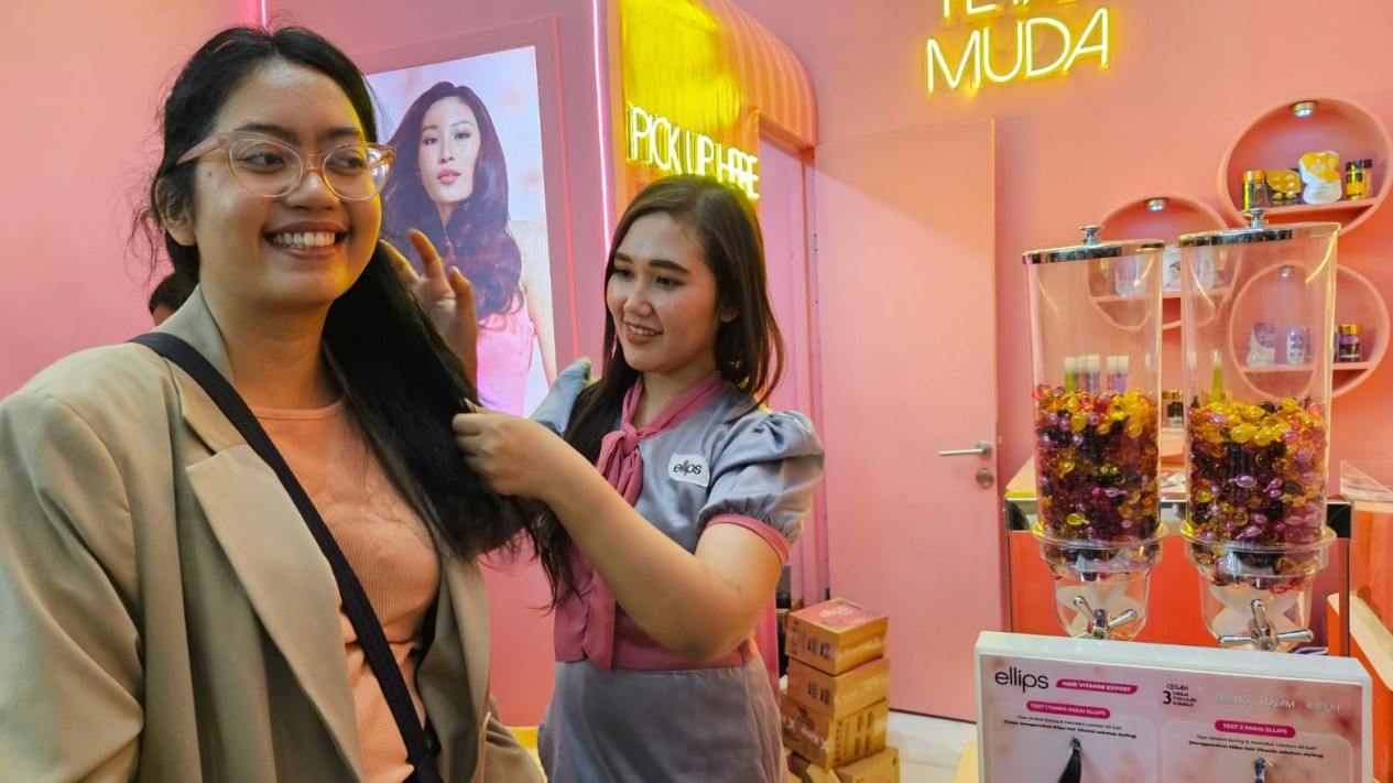 Pengunjung sedang mencoba salah satu produk perawatan rambut.