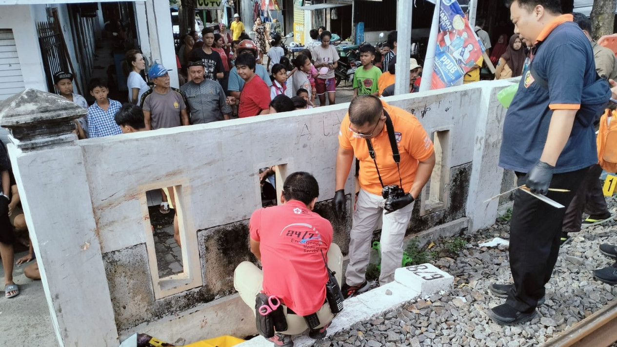 Petugas sedang mengevakuasi jenazah korban kecelakaan kereta api.