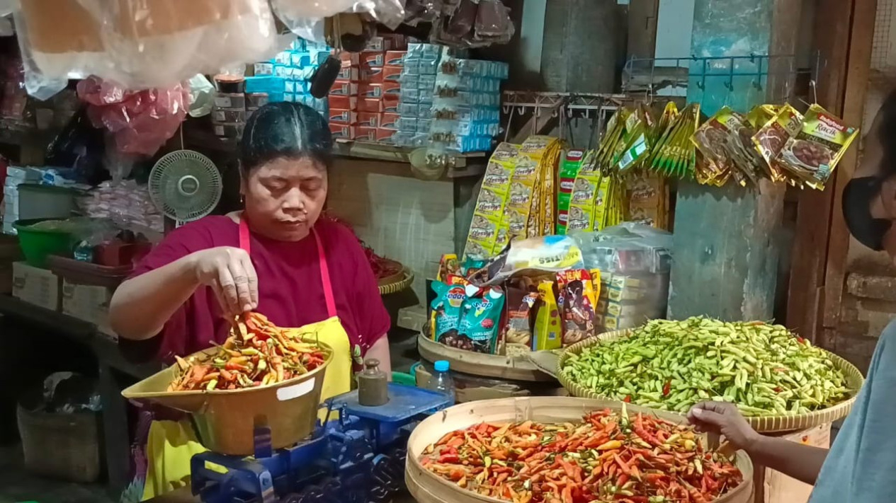 Pedagang sedang menimbang cabai