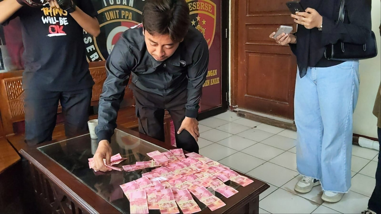 Polisi saat menunjukkan uang palsu