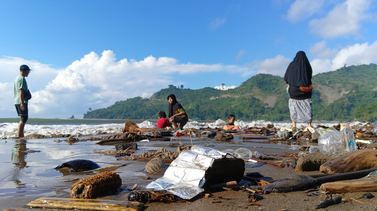 Wisatawan memungut sampah di Pantai Gemah