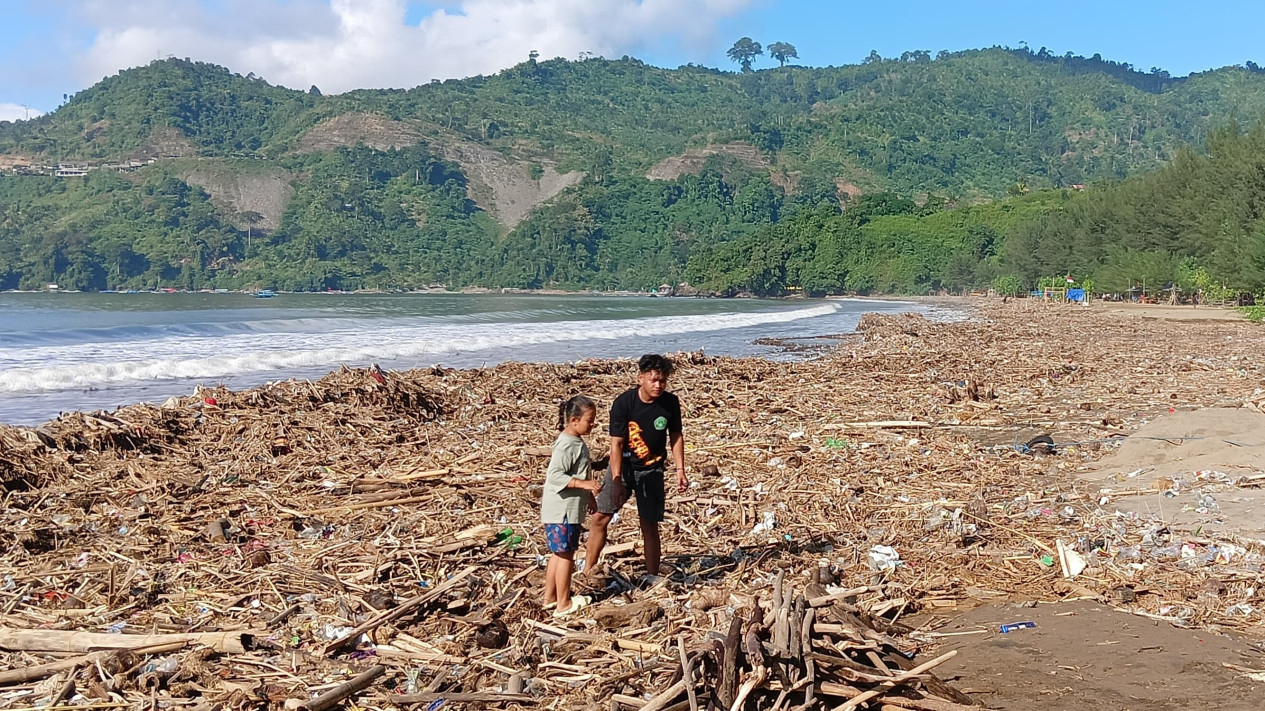 Keluarga pemilik lapak tengah membakar sampah di pantai.