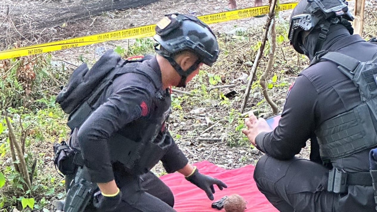Petugas saat mengevakuasi benda yang diduga sebagai granat
