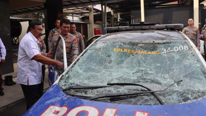Tim TGIPF melihat mobil polisi rusak akibat Tragedi Kanjuruhan.