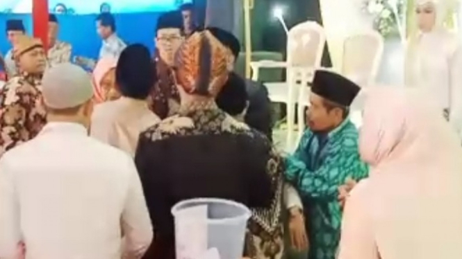 Warga menolong Kiai Zabidi yang pingsan di acara pernikahan.