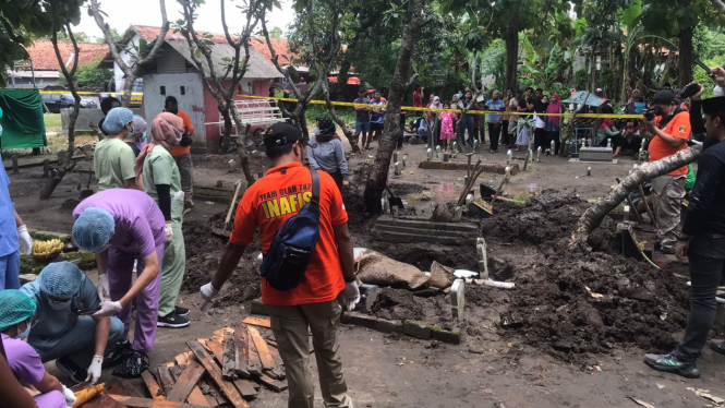 Proses pembongkaran makam korban penganiayaan di Mojokerto.