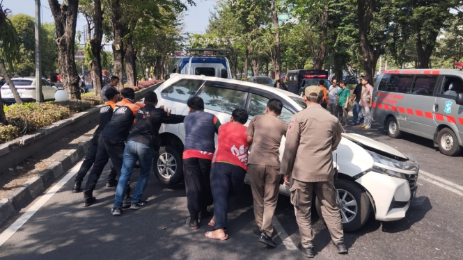 Petugas mengevakuasi mobil menabrak pohon di Surabaya.
