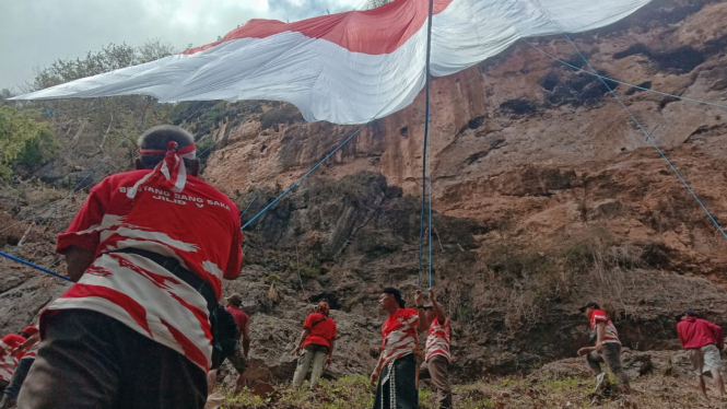 Proses pembentangan bendera di Tebing Wajakensis