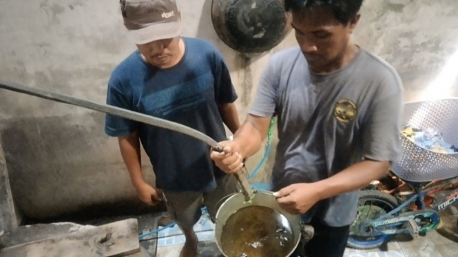Ketua RT 5 Kelurahan Tempurejo menimba air tercampur minyak