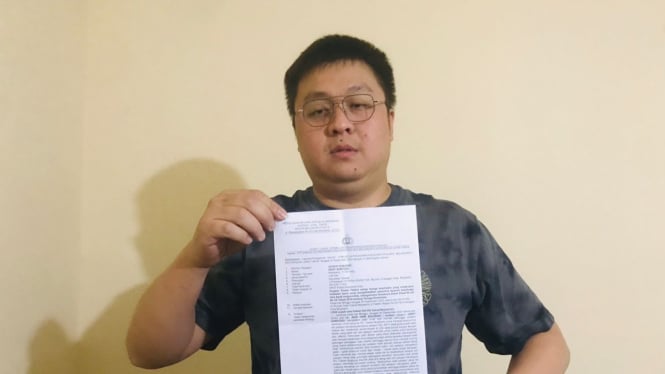 Hery Santoso menujukkan surat tanda terima laporan polisi