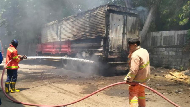 Petugas Damkarla memadamkan truk tronton yang terbakar di Gresik