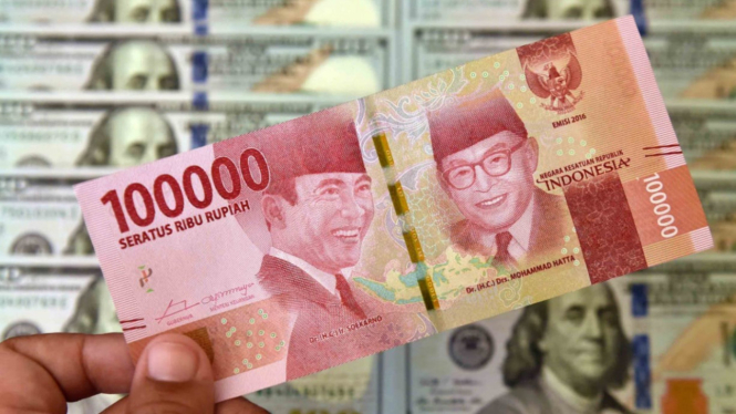 Petugas jasa penukaran valuta asing memeriksa lembaran  mata uang rupiah dan dolar AS di Jakarta