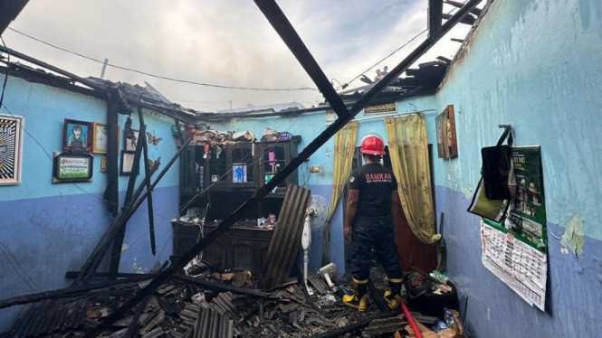 Petugas saat mengevakuasi rumah pasangan lansia Gresik yang terbakar