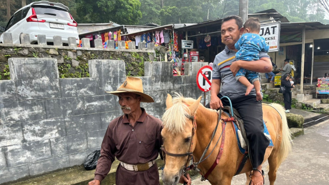 Wisatawan naik kuda di kawasan wisata Pacet Mojokerto