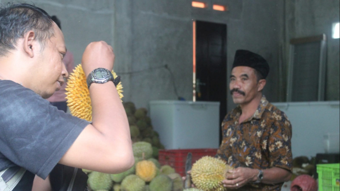 Pembeli sedang memilih buah durian di kios buah Desa Slawe Trenggalek.