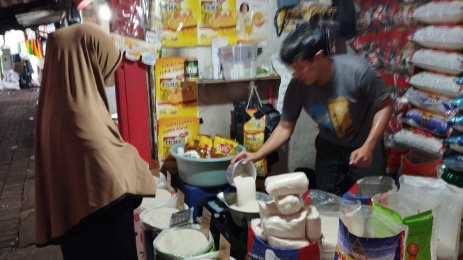 Pedagang beras di Pasar Pucang Anom Surabaya sedang melayani pembeli.