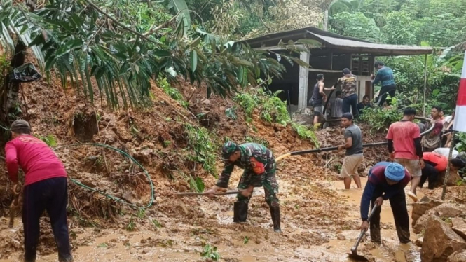 Petugas membersihkan tanah longsor di Desa Bangun, Trenggalek