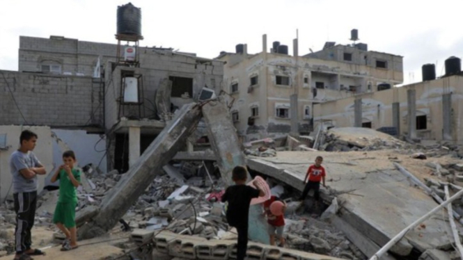 Anak-anak bermain di antara reruntuhan rumah yang hancur di Kota Rafah, Jalur Gaza bagian selatan