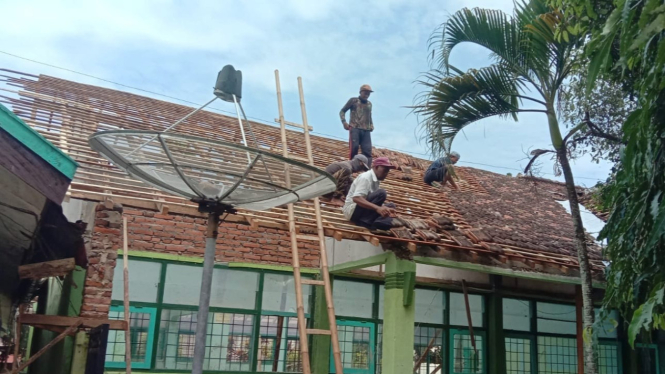 Pekerja merenovasi fasum di Pulau Bawean yang rusak akibat gempa.
