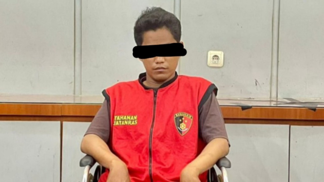 AR, di atas kursi roda dengan kondisi kedua kaki terluka