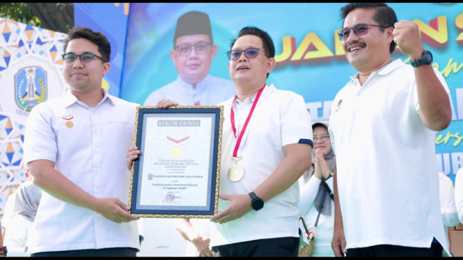 Pj Gubernur Jatim Adhy Karyono menerima piagam rekor MURI pengibaran bendera merah putih terbanyak di lingkungan masjid